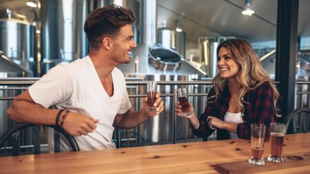 couple smiling and toasting beer at a craft brewery