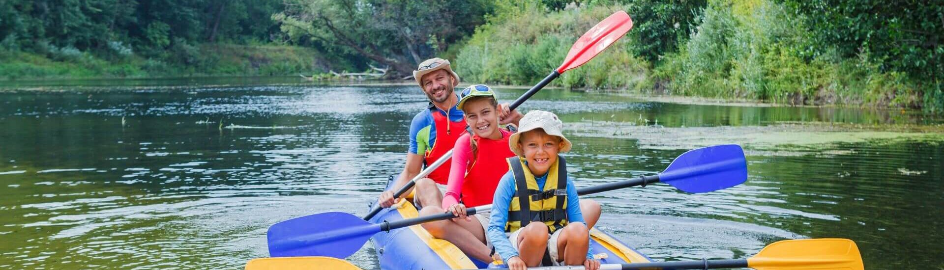 family on an inflatable kayak with paddles