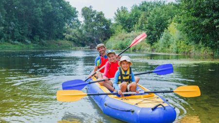 family on an inflatable kayak with paddles