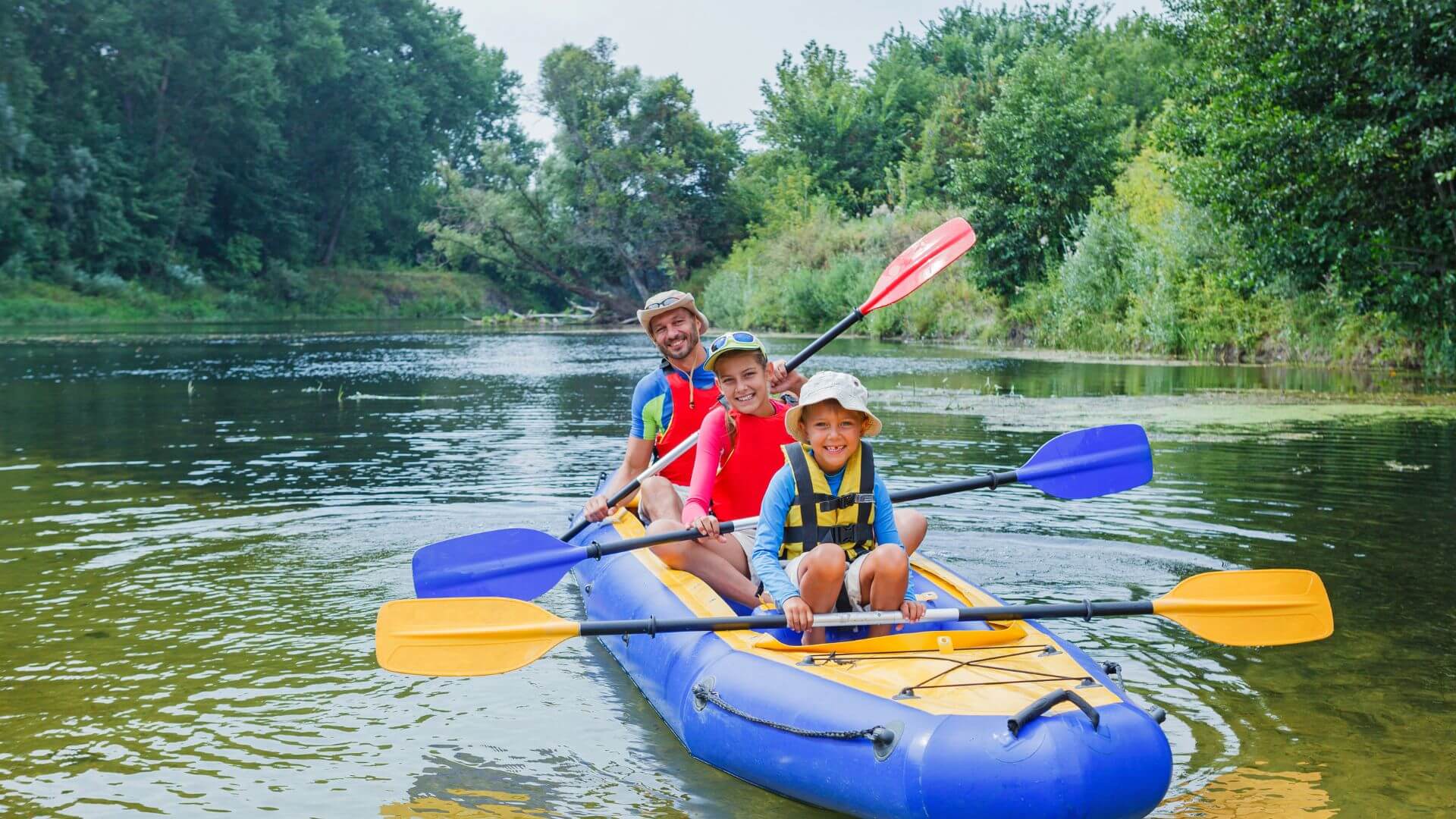 family on an inflatable kayak with paddles