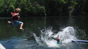 kid jumping into a lake
