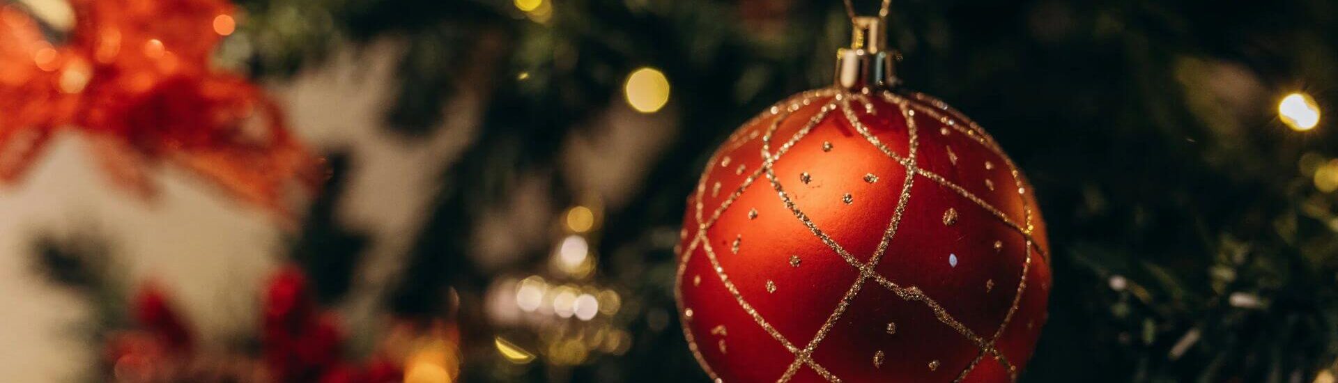 Glittering red ornament hangs on a Christmas tree, setting the mood for holiday shopping in Brattleboro, Vermont.