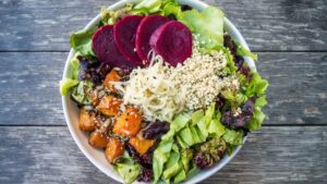 vegan dish with lettuce, couscous, beets, and roasted carrots